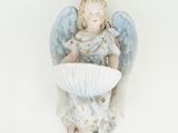 une figurine représentant un ange assis sur une table