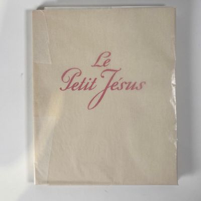 an old book with red writing on it sitting on a white surface