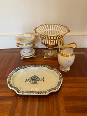 a wooden table with a bowl, vase, and plate on it