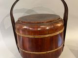 a large wooden bucket with a handle on display