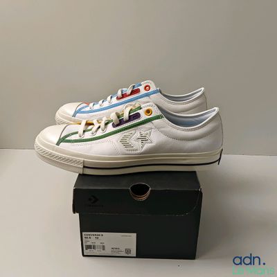 Des chaussures de tennis Nike ornées de rayures colorées sont présentées dans une boîte noire