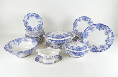 Des assiettes et des tasses en porcelaine bleue et blanche sont disposées sur une surface blanche