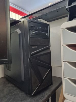 un ordinateur de bureau posé sur un bureau, à côté d'un écran