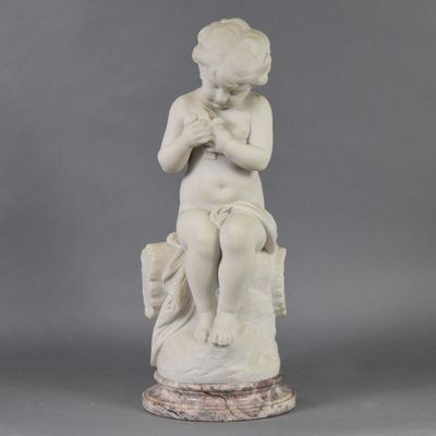 marble statue of a boy sitting on a rock with his hands clasped
