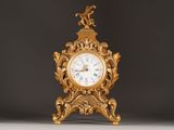 a gold clock sitting on top of a white table