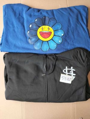 deux t-shirts ornés d'un smiley, posés sur une boîte en carton