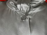 a close up of a mannequin wearing a silver jacket