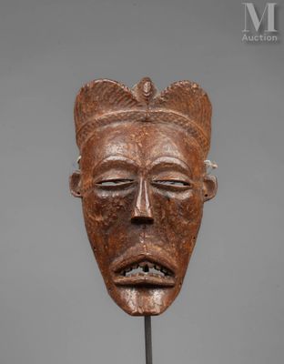 a close up of a wooden mask on a stick