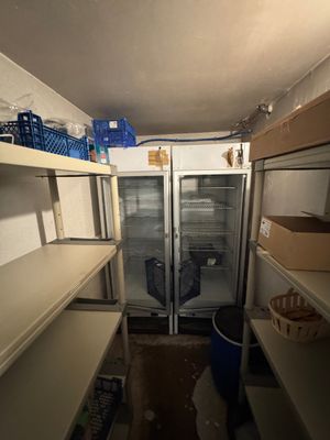 a refrigerator in the middle of a room with a lot of shelves