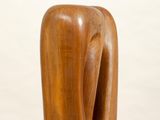 sculpture of a wooden elephant on a white pedestal against a white background