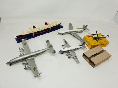 four model airplanes and a toy boat on a table