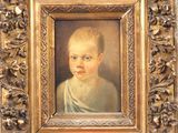 un tableau représentant un jeune garçon, dans un cadre doré
