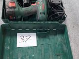 une boîte verte contenant des outils, posée sur le sol