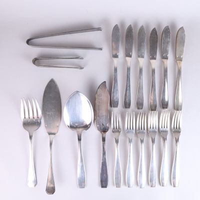 many forks and spoons laid out on a white surface
