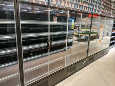 de nombreuses étagères vides dans un magasin qui regorge de produits alimentaires