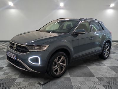 un SUV Volkswagen gris garé sur un sol en carrelage à damier