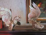 two figurines of birds that are on a table