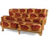 a red and yellow patterned couch with wooden legs