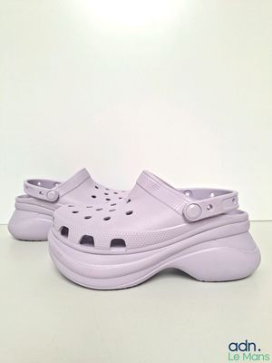 chaussures Crocs violettes percées de trous sur un fond blanc