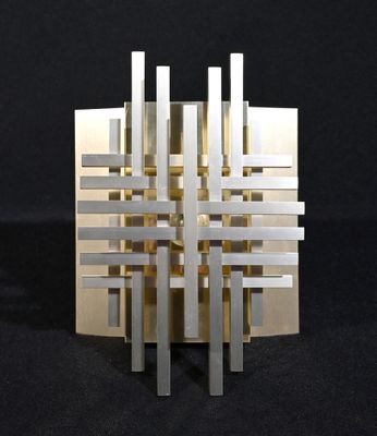 une sculpture réalisée à partir de bandes métalliques sur un fond noir