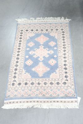 an image of a blue and pink rug on a grey floor