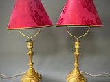 une paire de lampes de table en laiton avec des abat-jours roses et un abat-jour rouge
