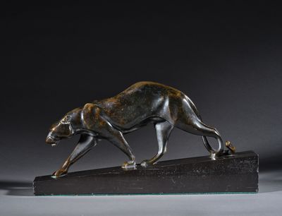 une photo d'une sculpture en bronze représentant un guépard sur un socle en marbre