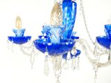 un lustre en verre orné d'une fleur bleue