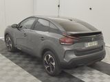 a grey car parked in a garage with a checkered floor