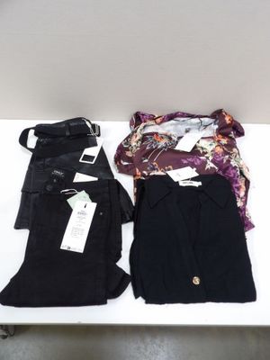 trois paires de pantalons noirs sont posées sur une table à côté d'un sac à main