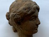 a clay head of a woman on a white surface