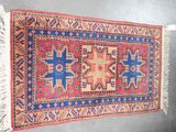 un vieux tapis accroché au mur, orné d'un motif bleu et rouge