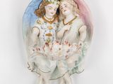 two figurines of angels on a white surface with a white background