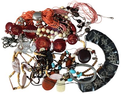 un tas de colliers et de bracelets assortis posés sur une surface blanche