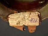 a small bag with a name on it sitting on top of a hat