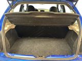 the back of a blue car with its trunk open and the seats down