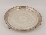 an antique silver plate with a design on the rim