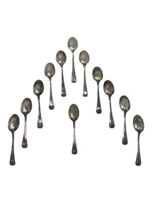 six silver spoons are arranged in a circle on a white surface