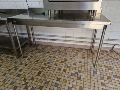 une table en acier inoxydable sur laquelle est posé un micro-ondes