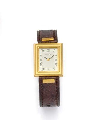 une photo d'une montre-bracelet plaquée or montée sur un bracelet en cuir marron