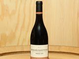 une bouteille de vin posée sur un tonneau