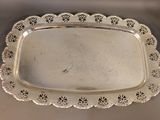 an antique silver plate with a decorative edge on a table