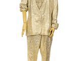 mannequin vêtu d'un costume doré, posé sur un socle métallique