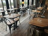 tables and chairs in a restaurant with large windows overlooking the street