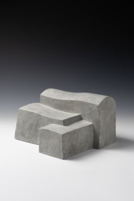 trois blocs de béton empilés les uns sur les autres sur une surface blanche