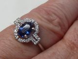 une personne tenant une bague sertie d'une pierre bleue