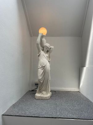 a statue of a woman holding a light in her hand