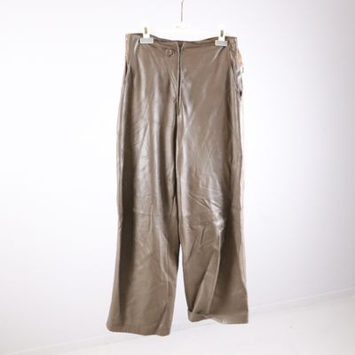leather pants hanging on a hanger in a white room