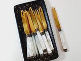 a black tray with a set of knives and a pen on it