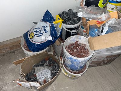 de nombreux seaux remplis de nourriture posés par terre près d'un mur